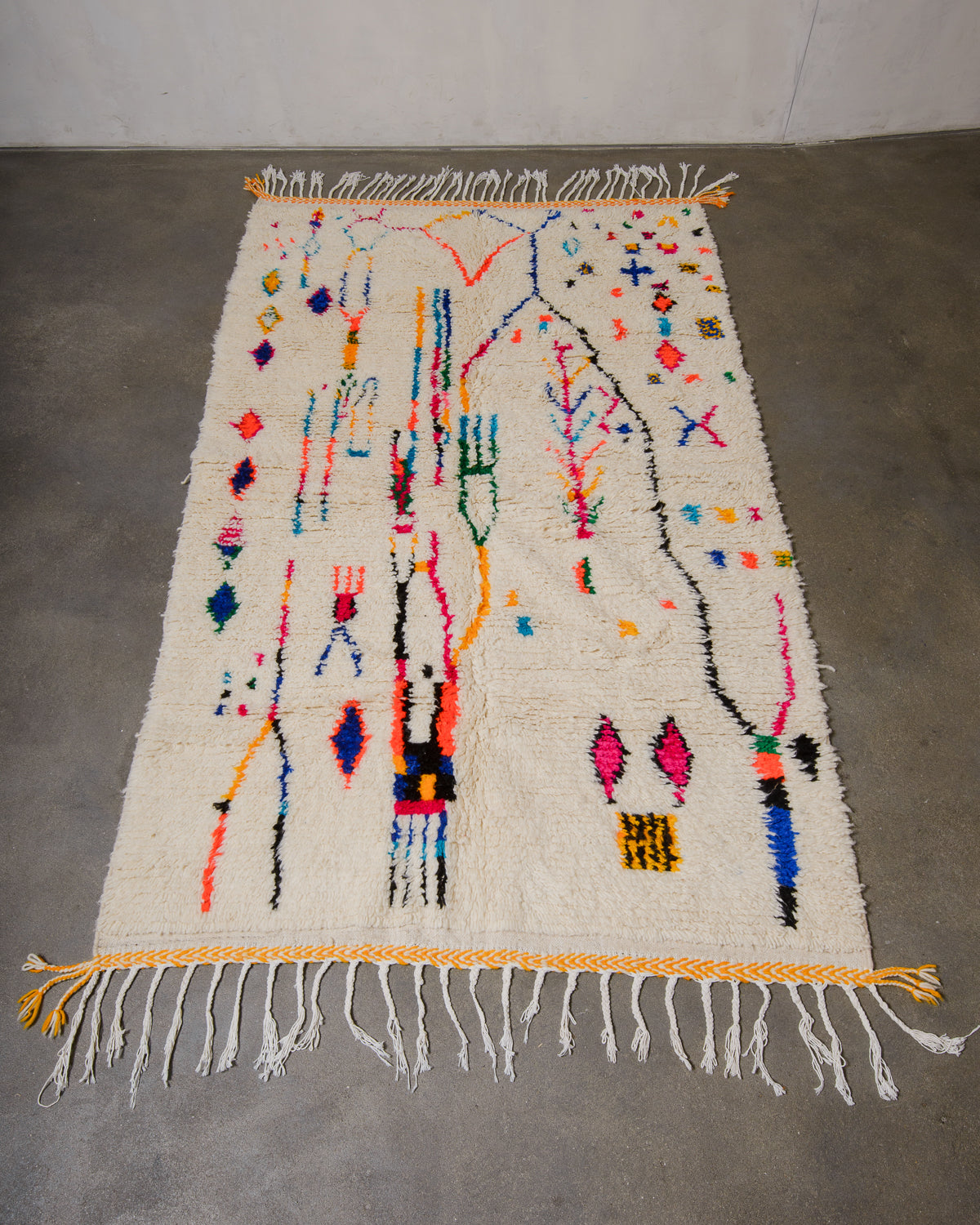 Berberlin Azilal rug made of fluffy wool and colourful cotton, laying flat on a concrete floor.